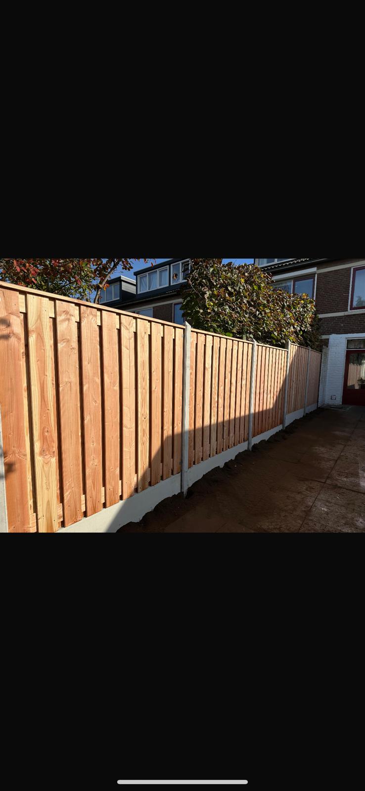 Hout schutting met betonnen onderbord