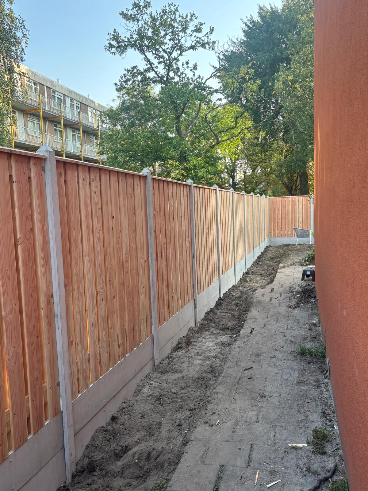 Hout schutting met betonnen onderbord